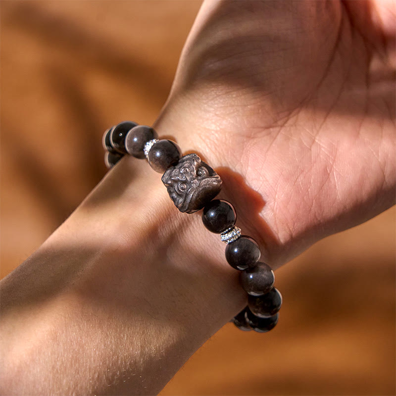 Buddha Stones Schutzarmband mit natürlichem Silberglanz-Obsidian und Löwentanz