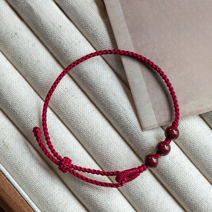 Buddha Stones Handgefertigtes Armband aus geflochtenem Seil mit Zinnoberperlen und dem Spruch „Ruhe und Segen“. - image 1