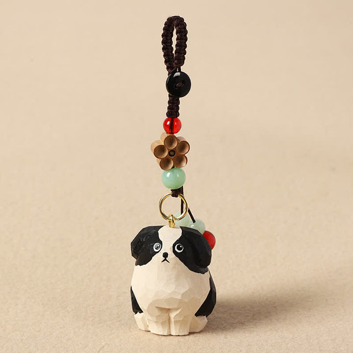 Buddha Stones Schlüsselanhänger mit geschnitztem Hund aus Holz und der Weisheit Om Mani Padme Hum - Schwarz-weißer Hund - image 0