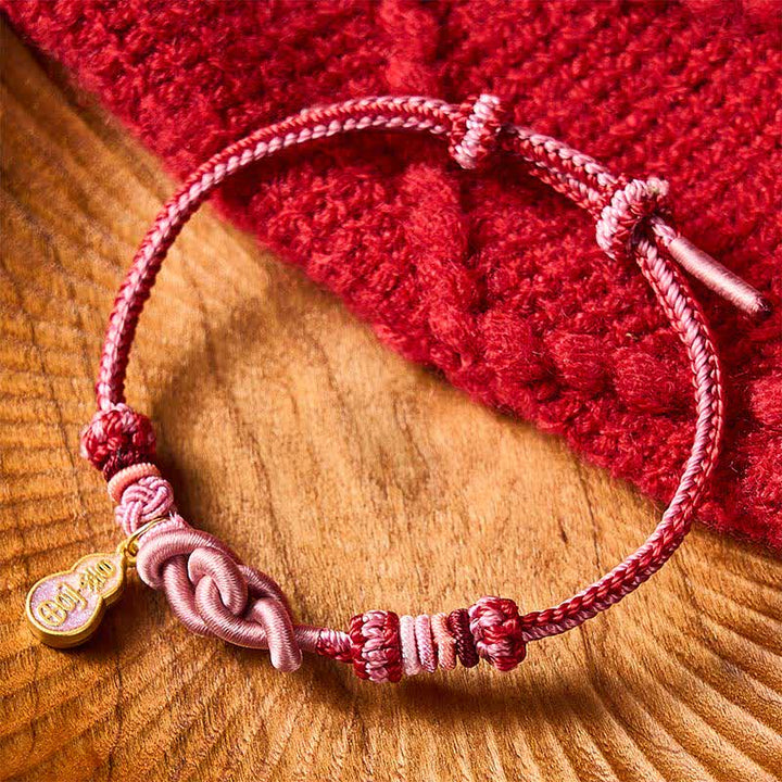 Buddha Stones Handgewebtes Armband aus rosafarbenem Kordelstoff mit dem Aufdruck „Schnell reich werden“ - image 1