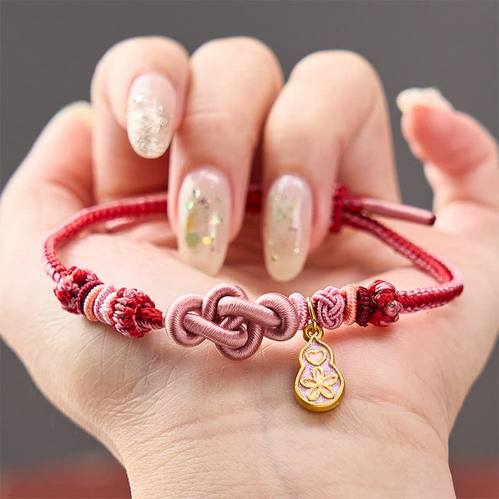 Buddha Stones Handgewebtes Armband aus rosafarbenem Kordelstoff mit dem Aufdruck „Schnell reich werden“ - Rosa mit Kürbis-Accessoire - image 0