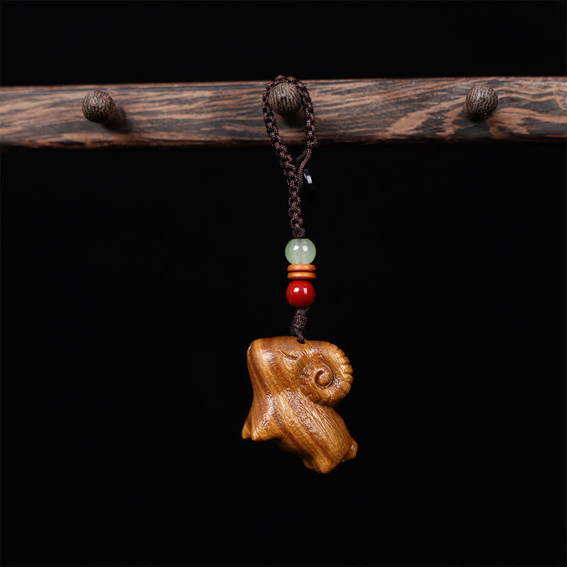 Buddha Stones Schlüsselanhänger aus rotem und grünem Sandelholz mit Ziegenmotiv, handgeschnitzt, Glücksbringer - Geflochtenes Seil - Grünes Sandelholz - image 1