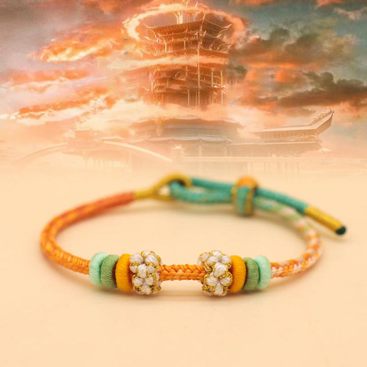 Buddha Stones Handgefertigtes achtfädiges Friedensknoten-Pfirsichblütenknoten-Glücksseil-geflochtenes Armband